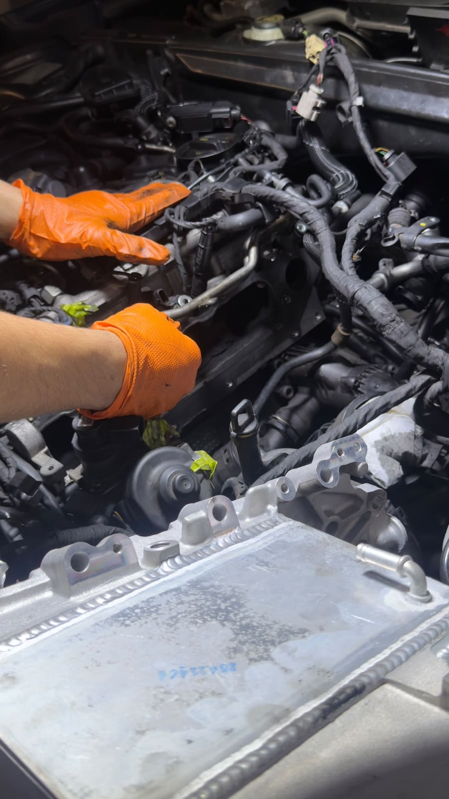 Technician working on an engine bay wiring harness